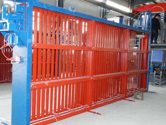Red safety guard fence with vertical bars on a blue machine frame