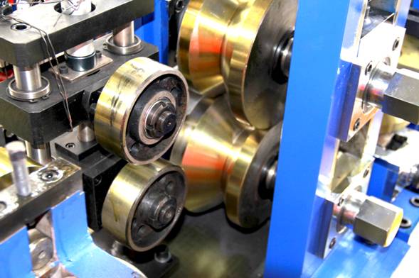 Close-up of forming rolls and shafts on a tube mill