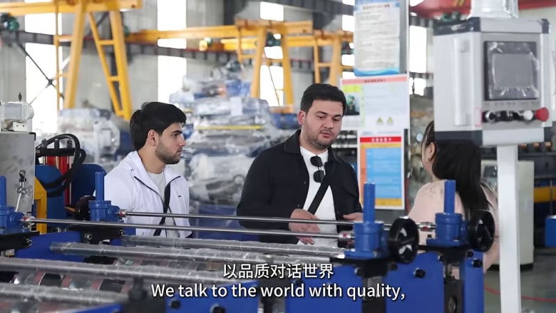 Customer and Zhongtuo staff at the welded pipe machine during the factory visit