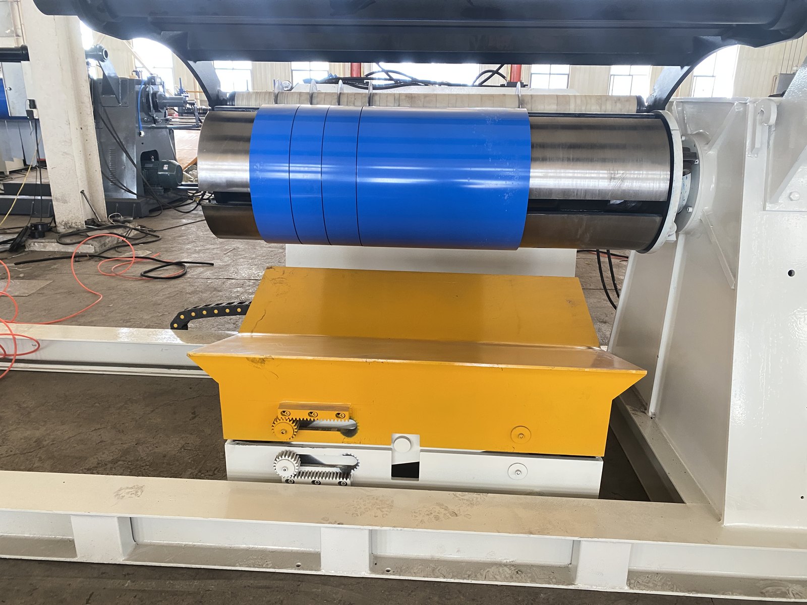 Hydraulic expanding mandrel decoiler holding a steel coil