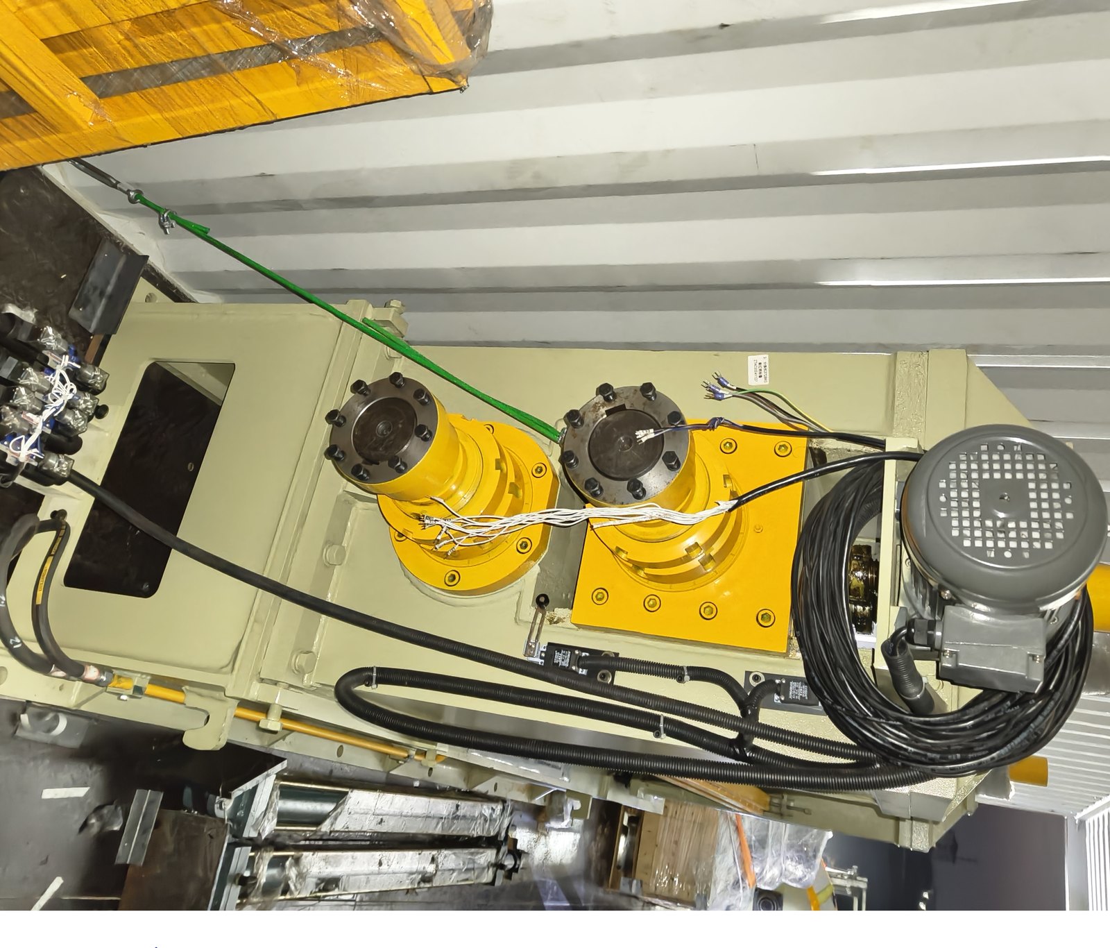 Drive motor and roll assembly braced inside a shipping container